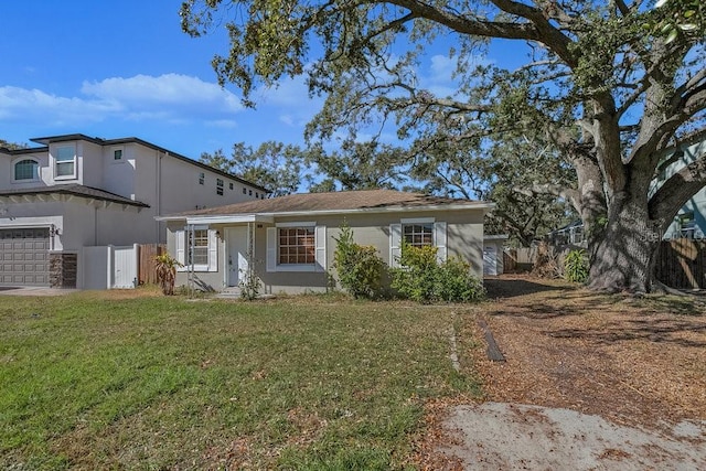 single story home featuring a garage and a front lawn