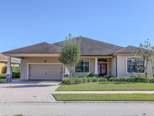 view of front of property featuring a front yard and a garage