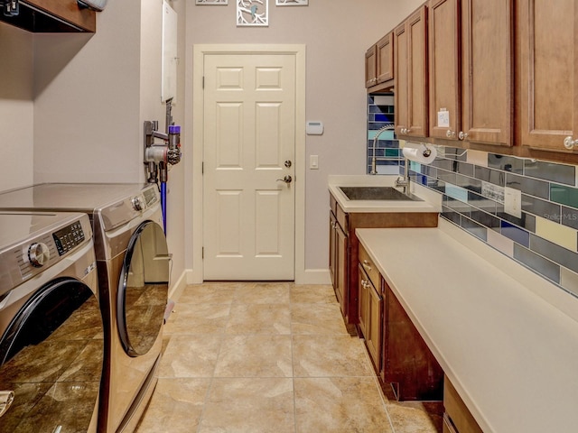 washroom with sink, light tile patterned floors, cabinets, and independent washer and dryer