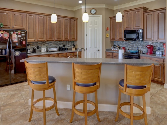 kitchen featuring black appliances, a breakfast bar, a kitchen island, and tasteful backsplash