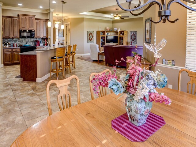 tiled dining room featuring ceiling fan and crown molding