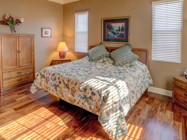 bedroom with hardwood / wood-style flooring and ornamental molding