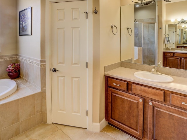 bathroom featuring tile patterned floors, vanity, and shower with separate bathtub