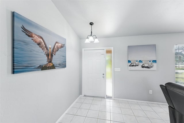 tiled foyer entrance featuring lofted ceiling and an inviting chandelier