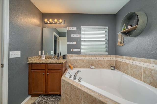 bathroom featuring vanity and tiled bath