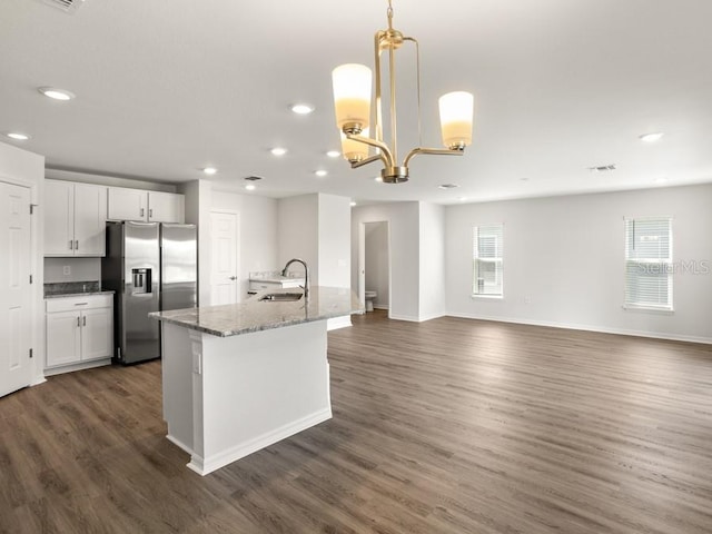 kitchen with stainless steel fridge, sink, dark hardwood / wood-style floors, white cabinetry, and hanging light fixtures