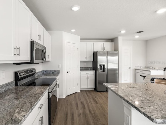 kitchen featuring appliances with stainless steel finishes, dark wood-type flooring, sink, stone countertops, and white cabinetry