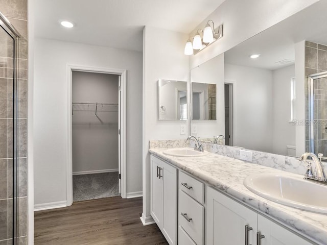 bathroom with vanity, wood-type flooring, and a shower with door