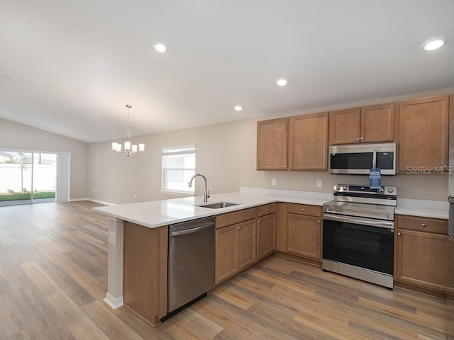 kitchen with sink, a wealth of natural light, kitchen peninsula, and appliances with stainless steel finishes