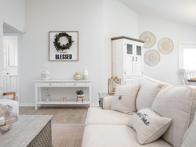 living room featuring high vaulted ceiling and light wood-type flooring