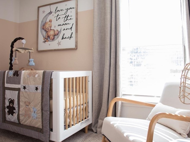 bedroom with carpet flooring and a nursery area