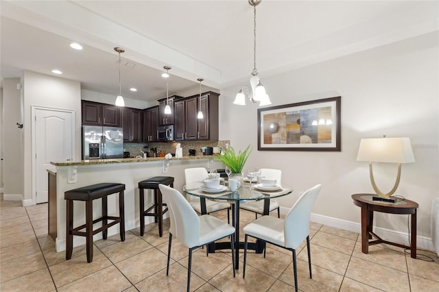 tiled dining space with an inviting chandelier