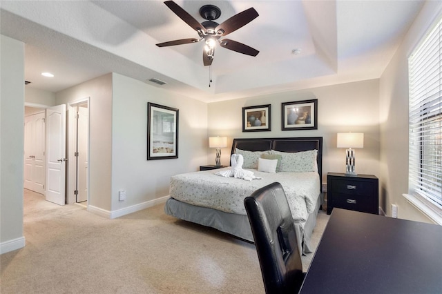 carpeted bedroom featuring a raised ceiling and ceiling fan