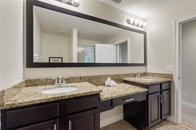 8205 Roseville, Davenport, FL 33896 - full bathroom with double vanity, a textured ceiling, tile patterned flooring, and baseboards