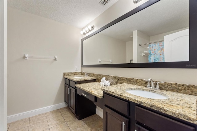 bathroom with a shower with curtain, tile patterned flooring, vanity, and a textured ceiling