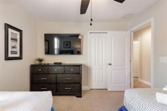 carpeted bedroom featuring a textured ceiling, a closet, and ceiling fan