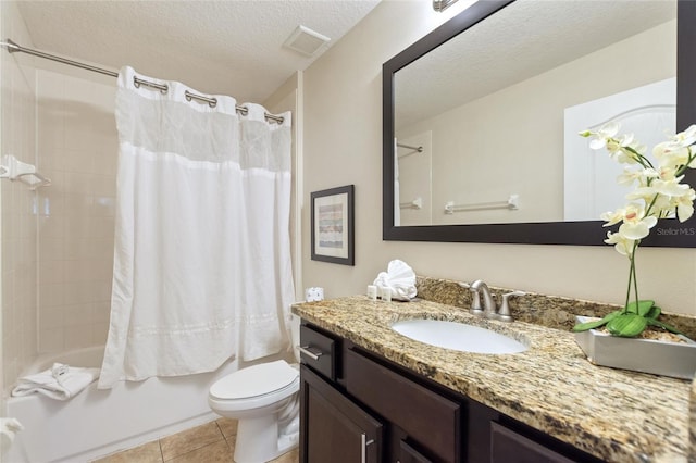 full bathroom featuring vanity, tile patterned flooring, toilet, shower / bath combo with shower curtain, and a textured ceiling