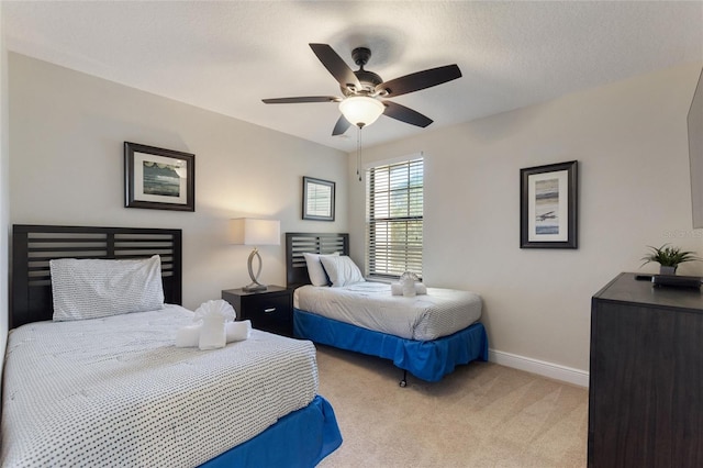 carpeted bedroom featuring ceiling fan and a textured ceiling