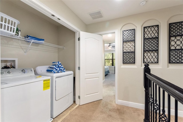 laundry area with ceiling fan, light colored carpet, and washing machine and clothes dryer