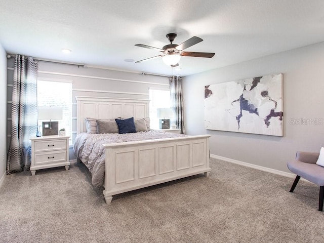 carpeted bedroom featuring multiple windows and ceiling fan