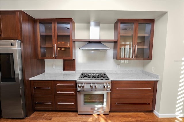 405 Central Ave Unit 210, Saint Petersburg, FL 33701 - kitchen with fridge, high end stove, backsplash, wood finished floors, and glass insert cabinets