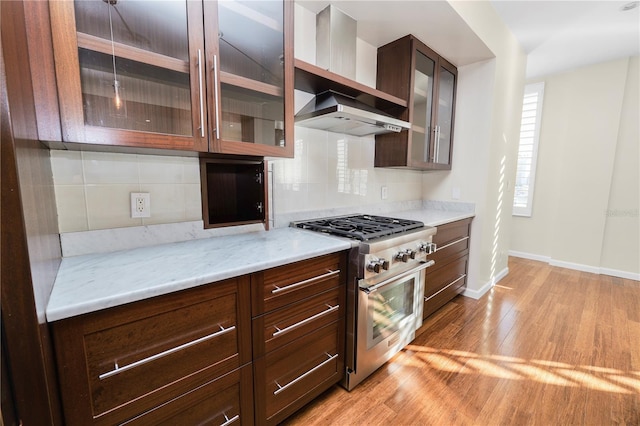 405 Central Ave Unit 210, Saint Petersburg, FL 33701 - kitchen featuring stainless steel range, light wood-style floors, backsplash, and baseboards