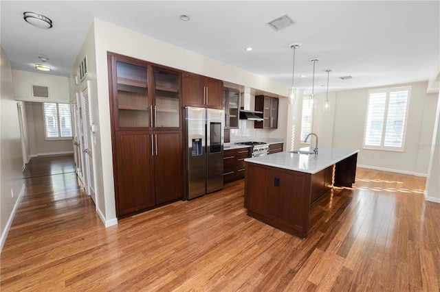 405 Central Ave Unit 210, Saint Petersburg, FL 33701 - kitchen with appliances with stainless steel finishes, a sink, light countertops, light wood finished floors, and wall chimney range hood