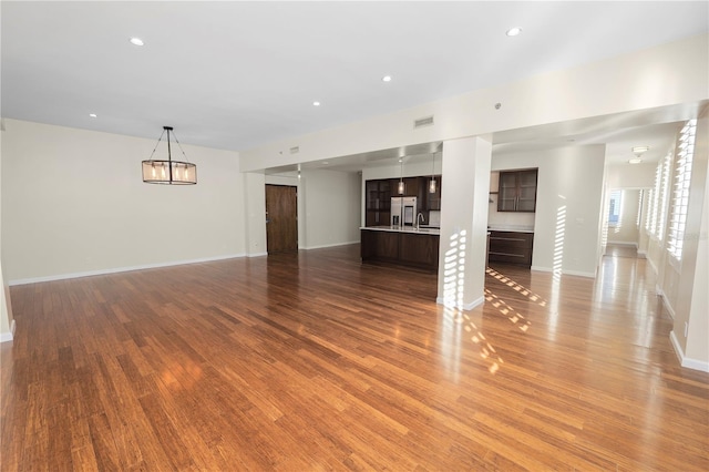 unfurnished living room with hardwood / wood-style floors and sink