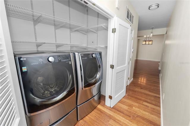 405 Central Ave Unit 210, Saint Petersburg, FL 33701 - washroom featuring washing machine and dryer, light wood-type flooring, and baseboards