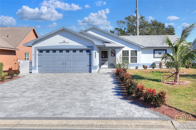 single story home with a garage and a front lawn