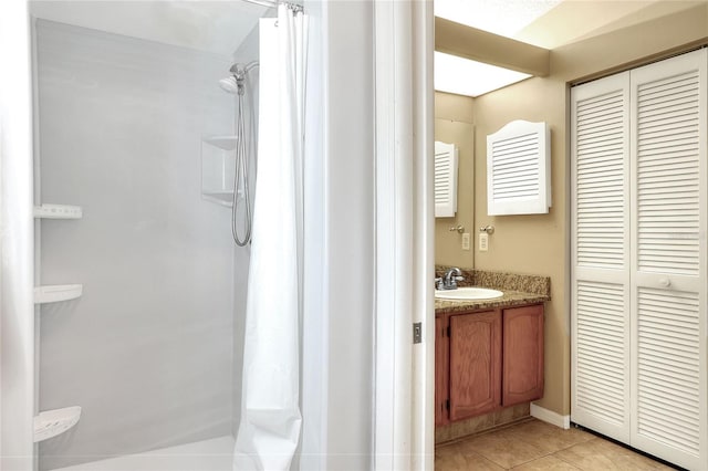 bathroom featuring tile patterned flooring, vanity, and curtained shower