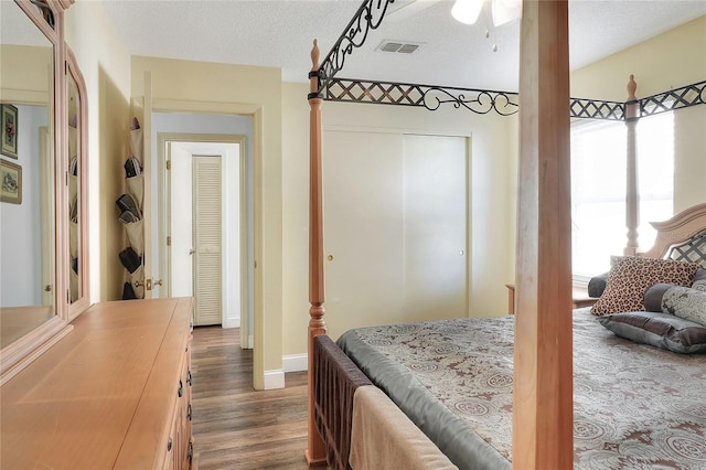 bedroom featuring a textured ceiling, a closet, and dark wood-type flooring