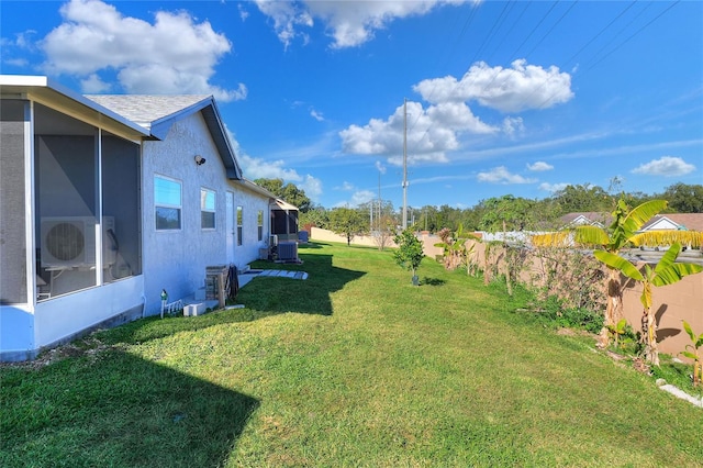 view of yard with a sunroom, ac unit, and cooling unit