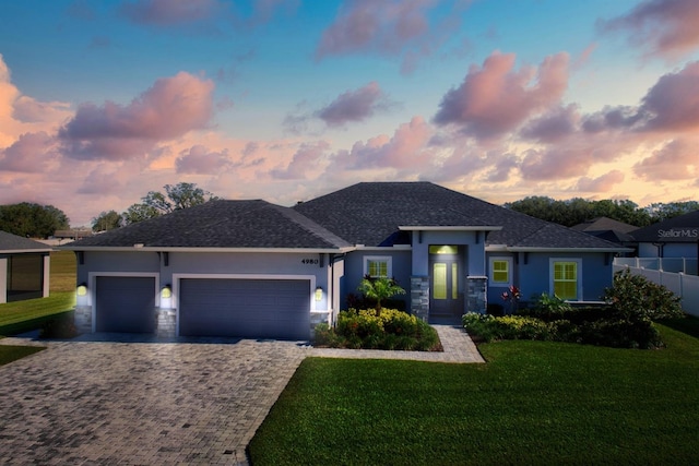 prairie-style house featuring a yard and a garage