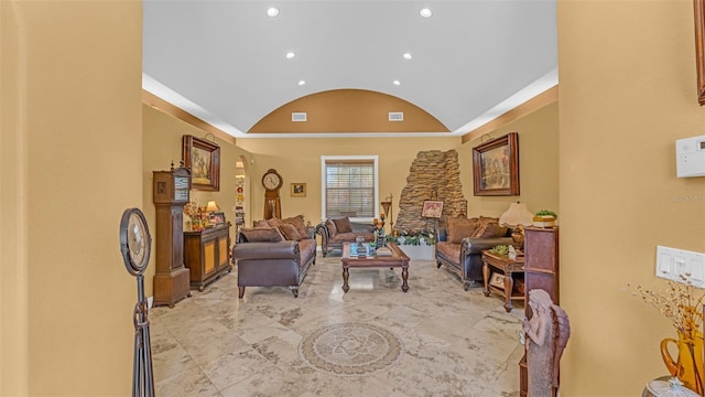 living room with a stone fireplace and vaulted ceiling