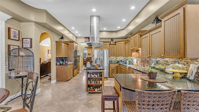 kitchen featuring light brown cabinets, sink, decorative backsplash, appliances with stainless steel finishes, and island exhaust hood