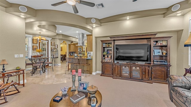 living room featuring ceiling fan with notable chandelier and light tile patterned floors