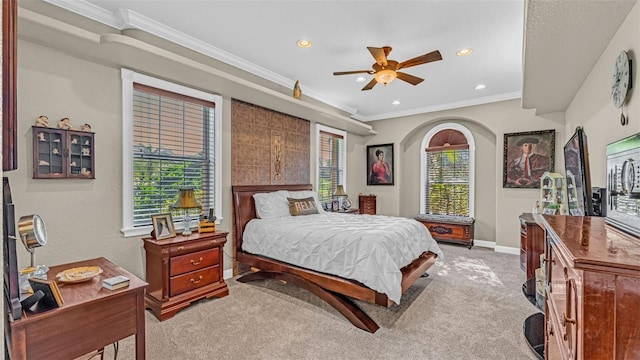 carpeted bedroom with multiple windows, ornamental molding, and ceiling fan