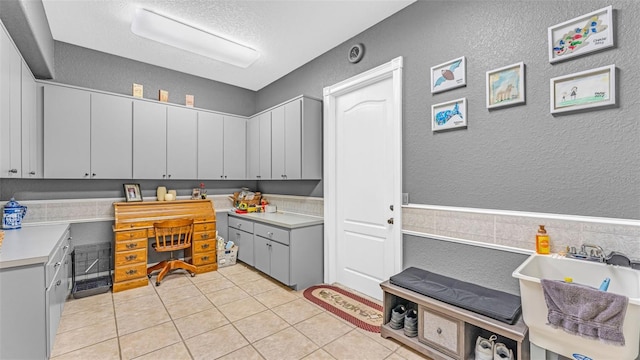 kitchen featuring light tile patterned floors, gray cabinets, and sink