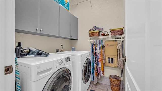 laundry area with cabinets, light tile patterned floors, and washer and dryer