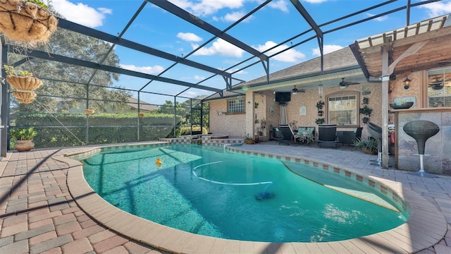 view of pool with ceiling fan, a lanai, and a patio