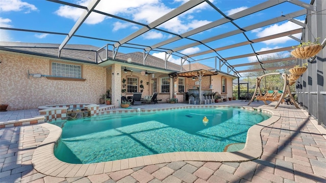 view of swimming pool with a bar, a patio area, ceiling fan, and a lanai