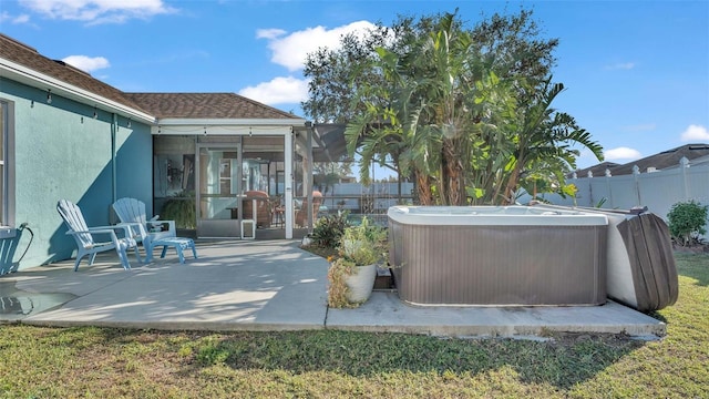 view of patio / terrace with a hot tub and a sunroom