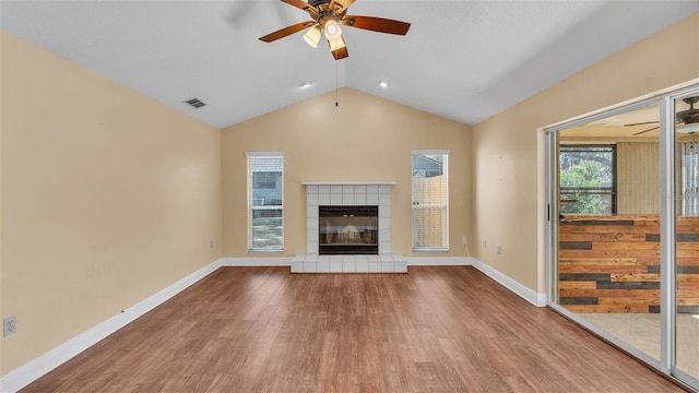 unfurnished living room featuring lofted ceiling, a fireplace, visible vents, and wood finished floors