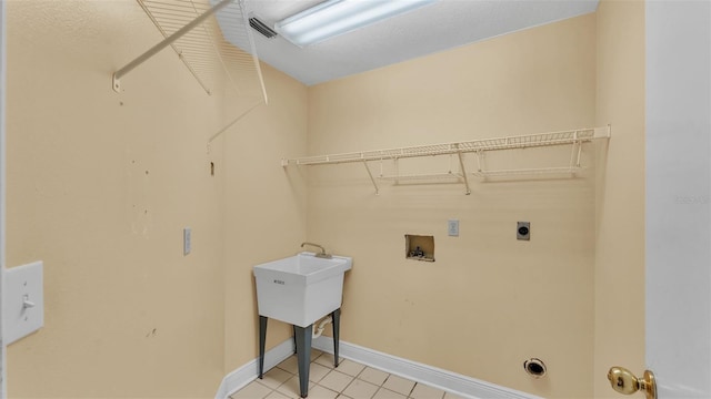 laundry room with laundry area, light tile patterned floors, baseboards, hookup for a washing machine, and hookup for an electric dryer