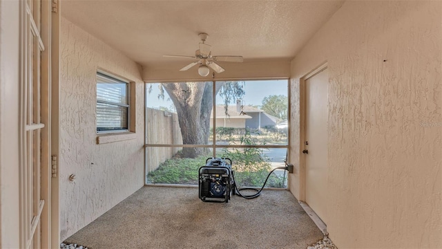 unfurnished sunroom featuring a ceiling fan