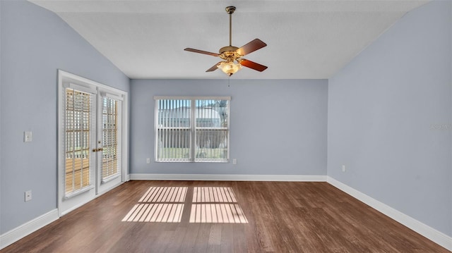 spare room featuring ceiling fan, vaulted ceiling, baseboards, and wood finished floors