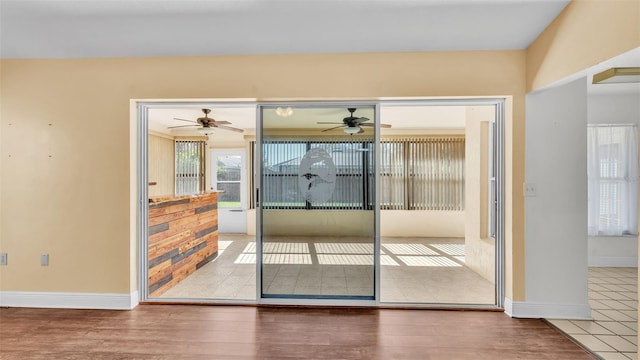 doorway to outside featuring baseboards and wood finished floors