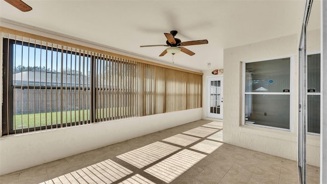 unfurnished sunroom with ceiling fan