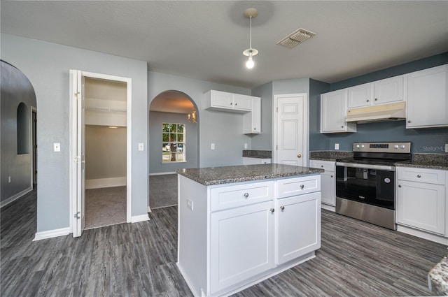 kitchen with stainless steel range with electric stovetop, a kitchen island, dark stone countertops, and white cabinetry